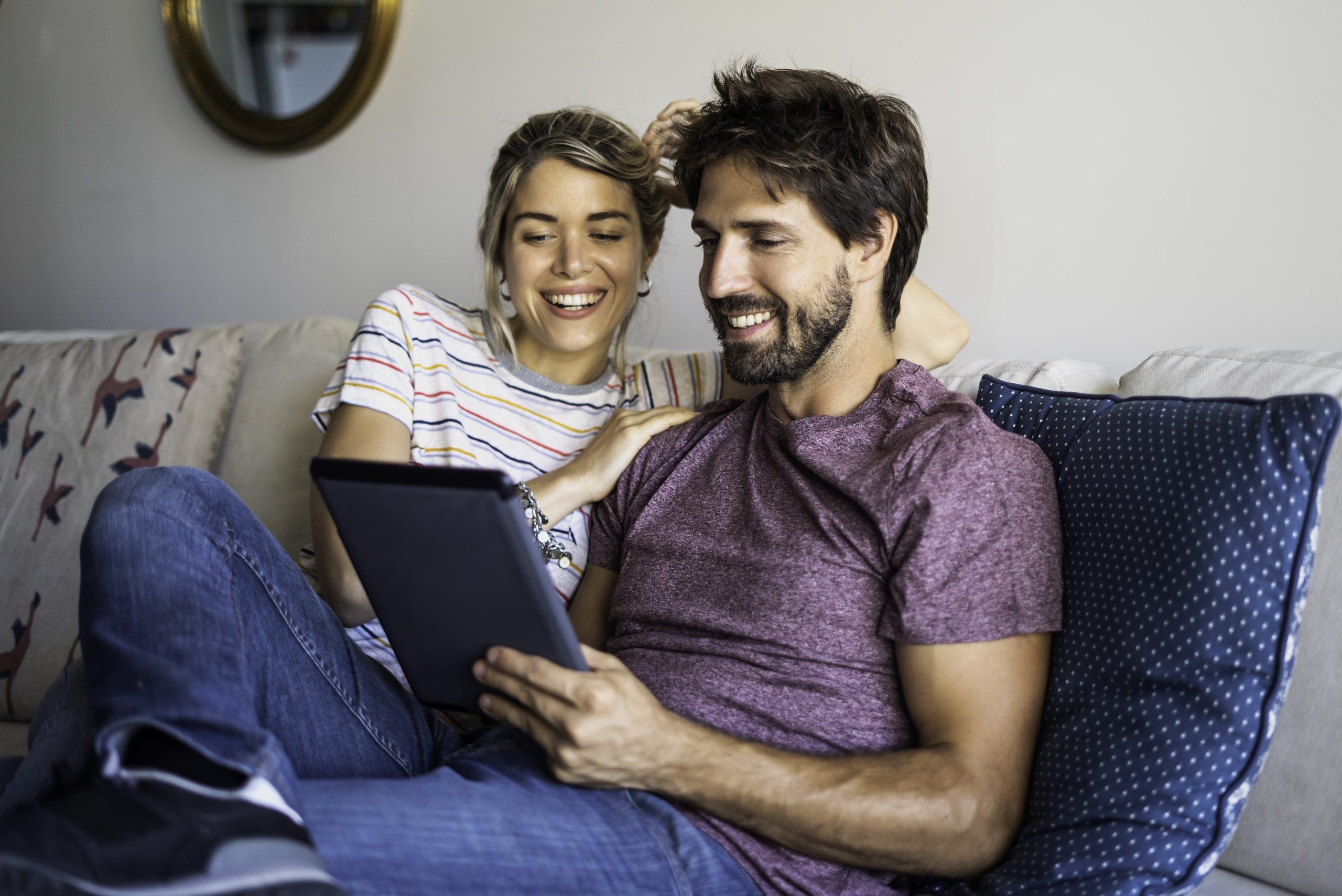 Couple using digital tablet at home